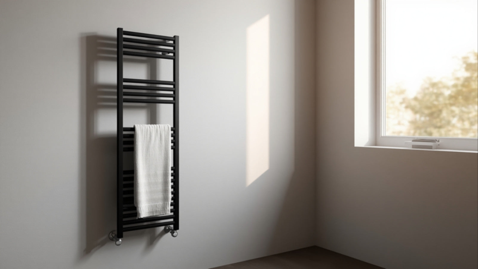 Zwarte elektrische handdoekradiator met handdoek in een lichte minimalistische badkamer